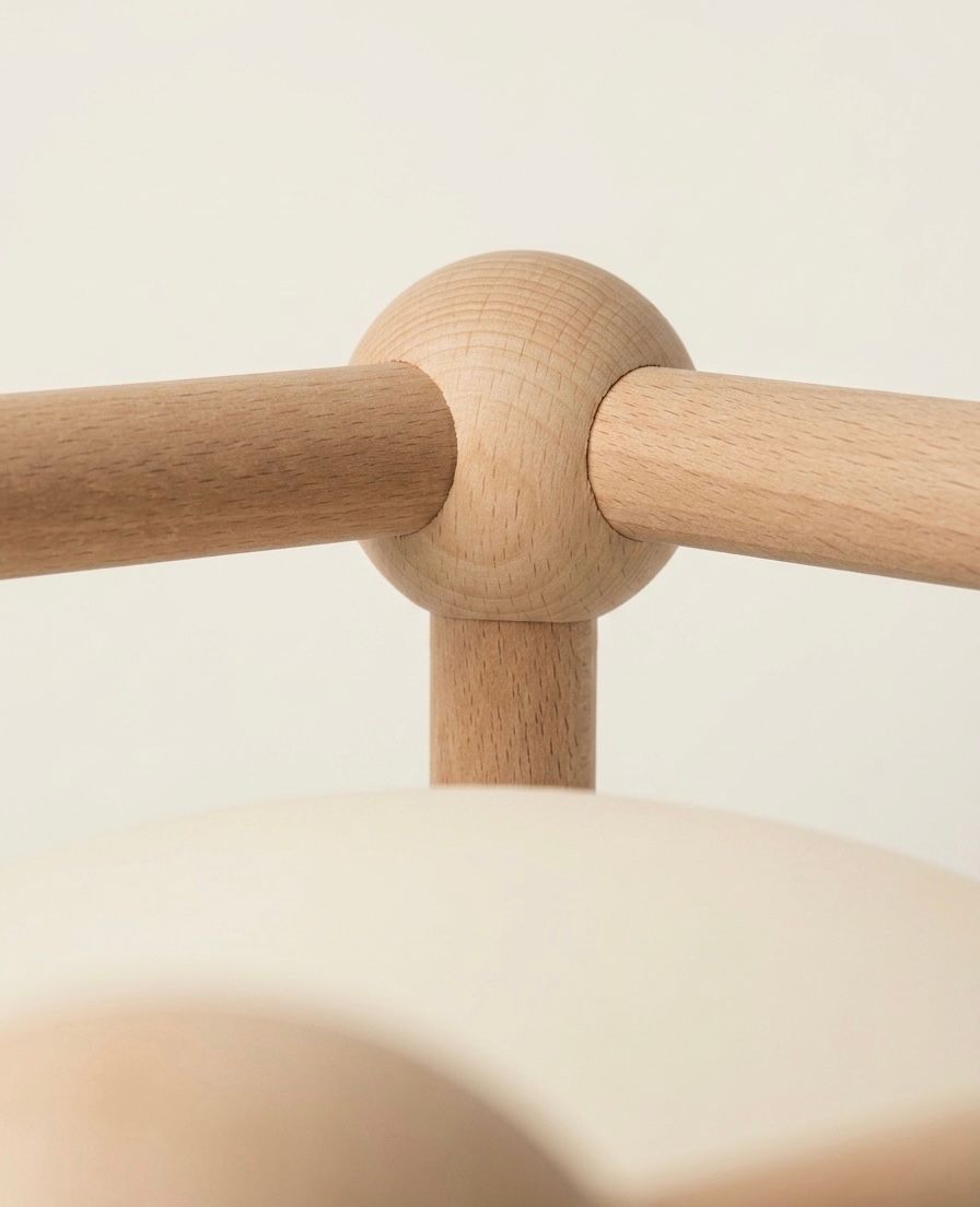 Rounded wooden joints connecting the frame of a lighting object.